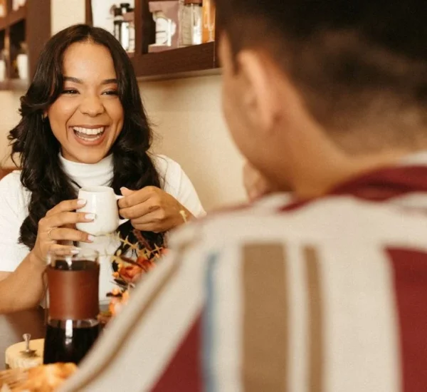 Pareja platicando y riendo durante una cita en una cafetería