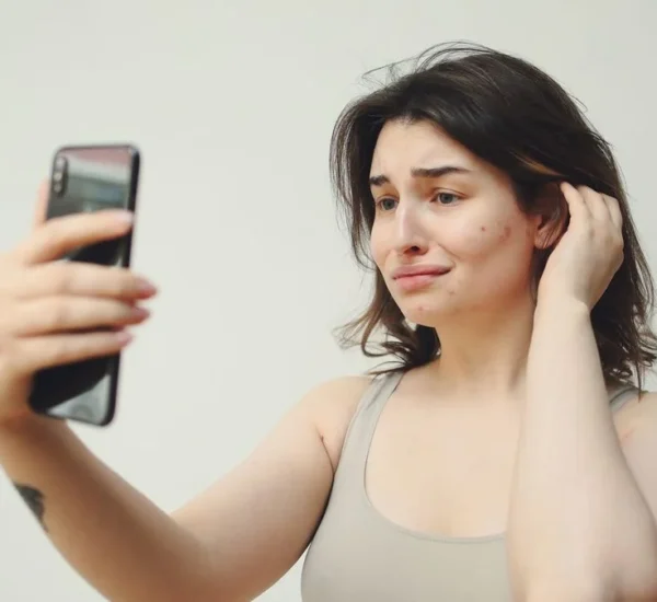 Mujer con gesto de preocupación mirando su celular