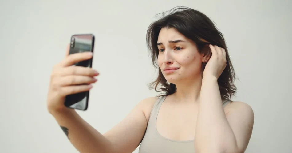 Mujer con gesto de preocupación mirando su celular