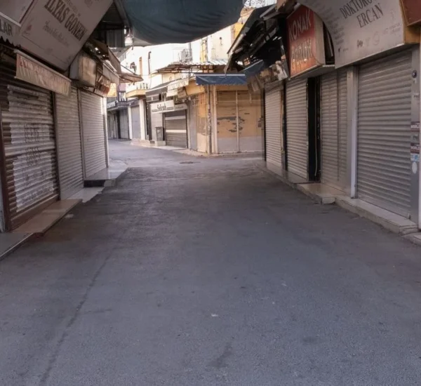 Calle con las cortinas de los locales comerciales cerradas