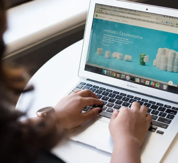 Manos escribiendo la dirección de un sitio web en una laptop